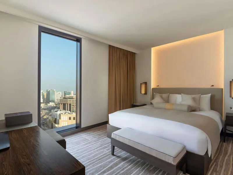Chambre moderne avec un grand lit et une vue sur la ville.