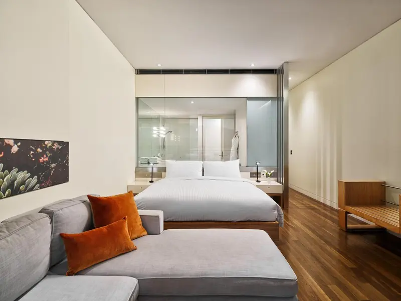 Une chambre lumineuse avec un grand lit et un coin salon.