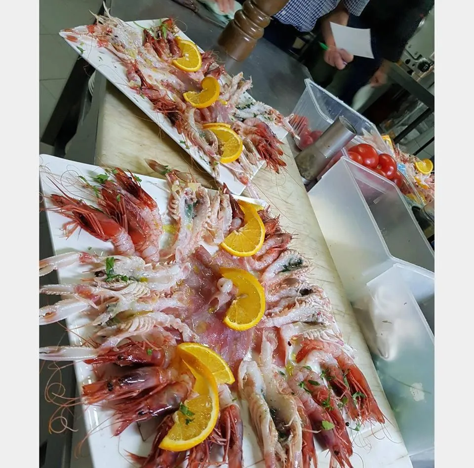 Présentation de fruits de mer frais sur un plateau rectangulaire.
