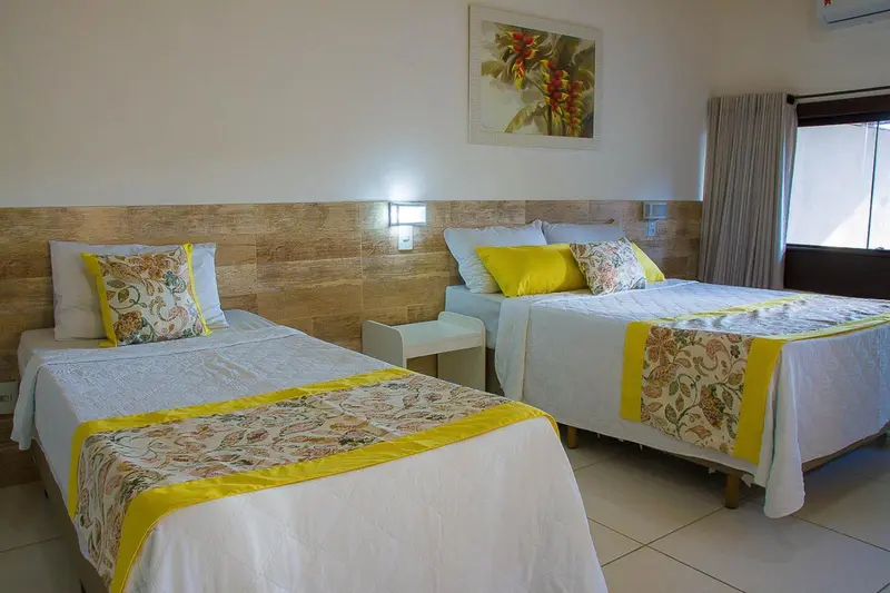 Deux lits simples avec une décoration florale dans une chambre lumineuse.