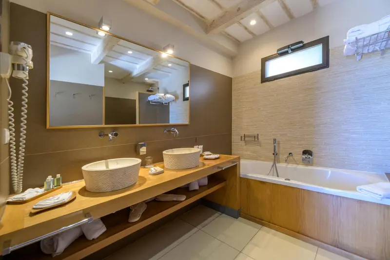 Une salle de bain lumineuse avec deux vasques et une baignoire.
