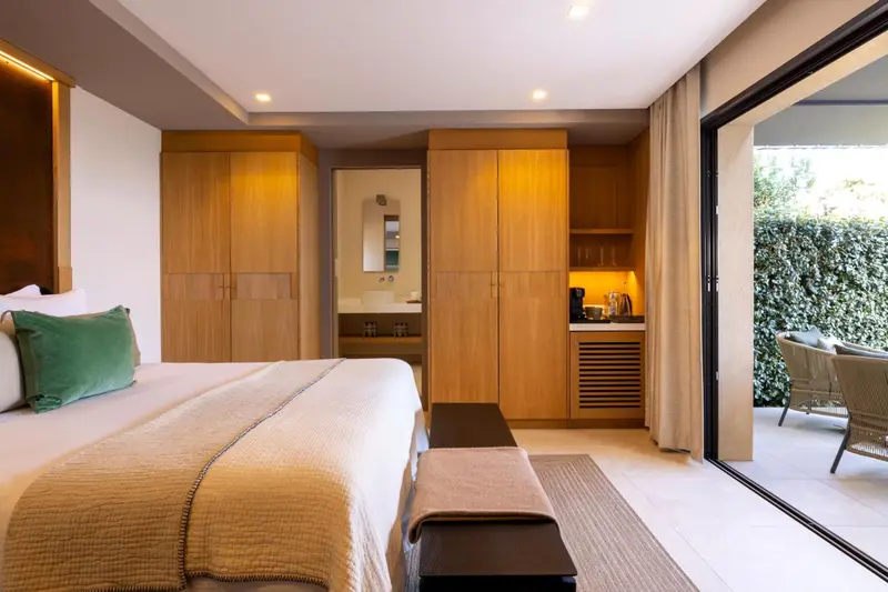 Une chambre lumineuse avec un grand lit et un accès à une terrasse.
