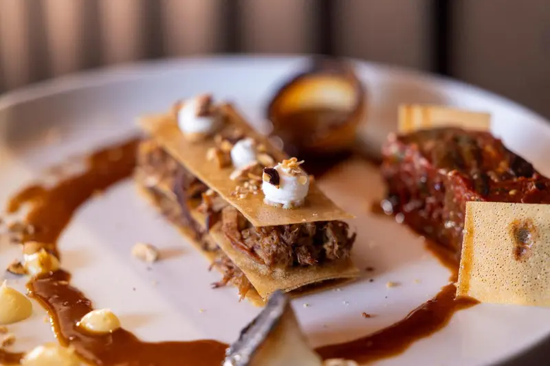 Assiette de dessert raffiné avec des textures variées et une sauce caramel.