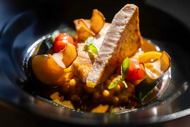 Assiette de poisson servi avec des légumes et des lentilles.