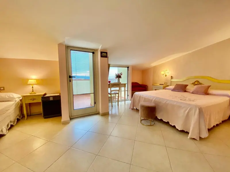 Chambre lumineuse avec un lit double et un accès à une terrasse.