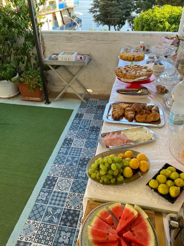 Une table est dressée avec des pâtisseries, des fruits et des viennoiseries.