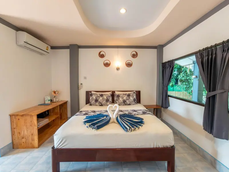 Une chambre lumineuse avec un lit double décoré de serviettes en forme de cygnes.