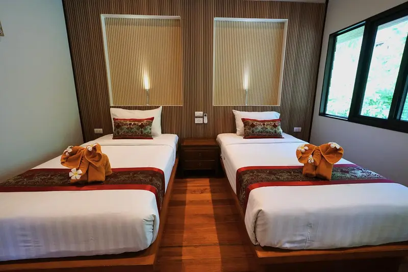 Chambre avec deux lits simples décorés de fleurs.