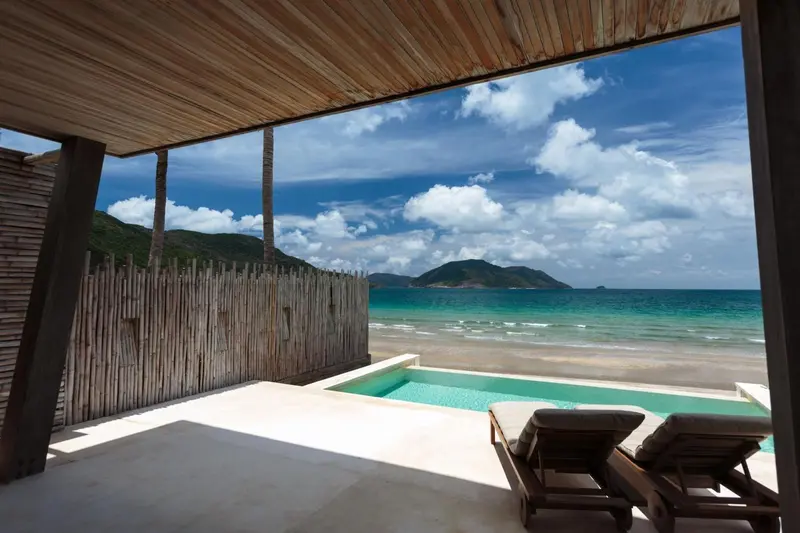 Terrasse avec piscine privative donnant sur une plage de sable fin et la mer.