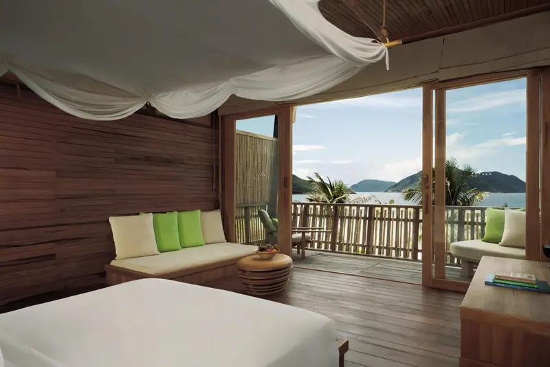 Une chambre lumineuse s'ouvre sur une terrasse avec vue sur la mer.