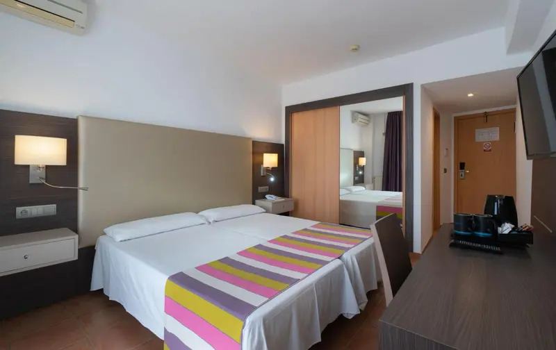 Une chambre d'hôtel lumineuse avec un grand lit et un coin bureau.