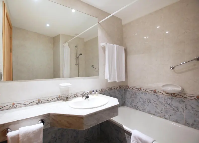 Une salle de bain claire avec baignoire et lavabo.