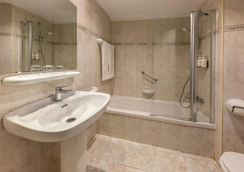 Une salle de bain claire avec baignoire et lavabo.