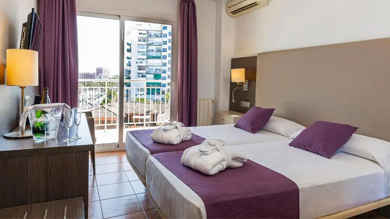 Une chambre lumineuse avec un lit double et un balcon.
