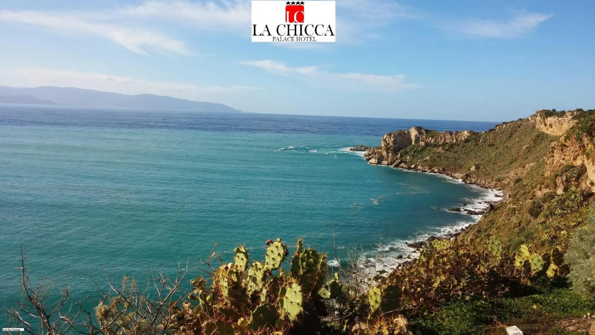 Vue panoramique sur une côte rocheuse et la mer turquoise.