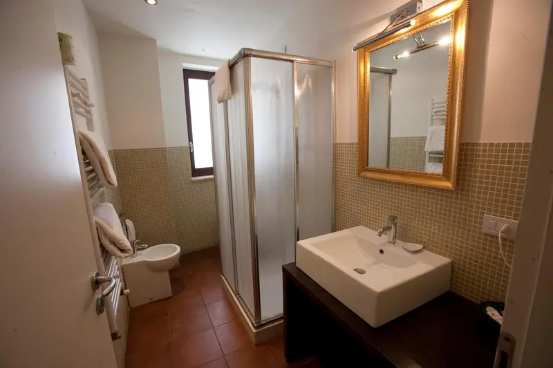 Une salle de bain claire avec douche vitrée et lavabo.