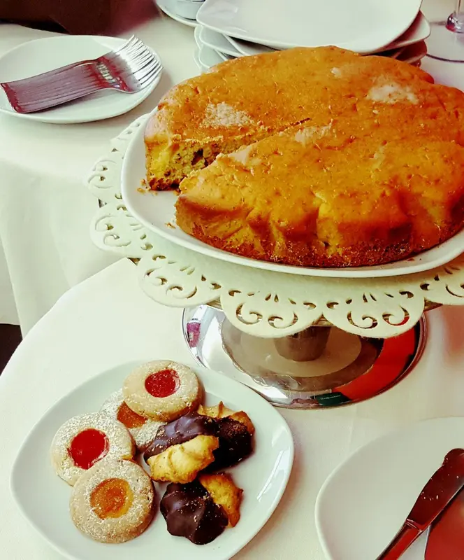 Une table dressée présente un gâteau et des pâtisseries.