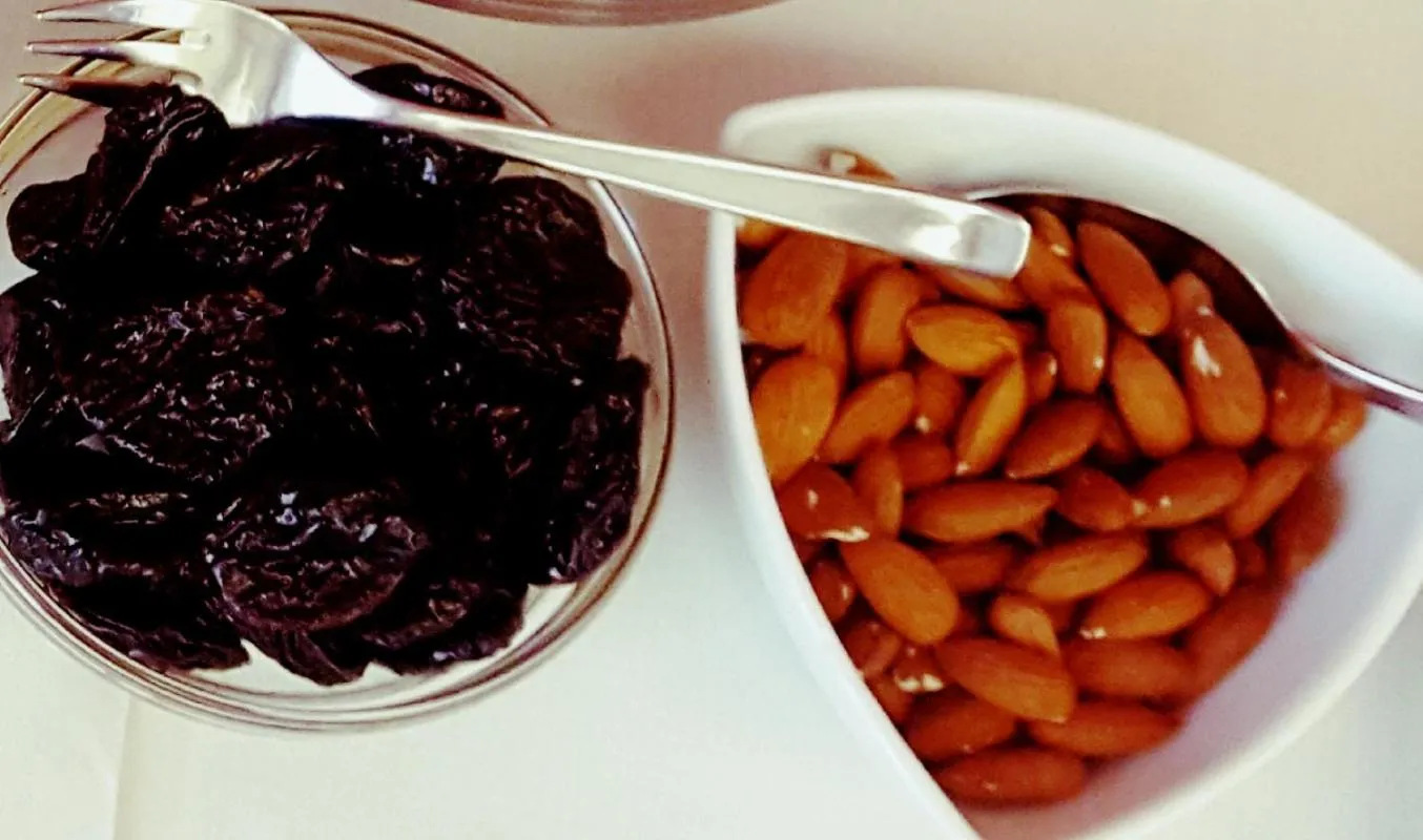 Assiettes de fruits secs et d'amandes présentées sur une table.