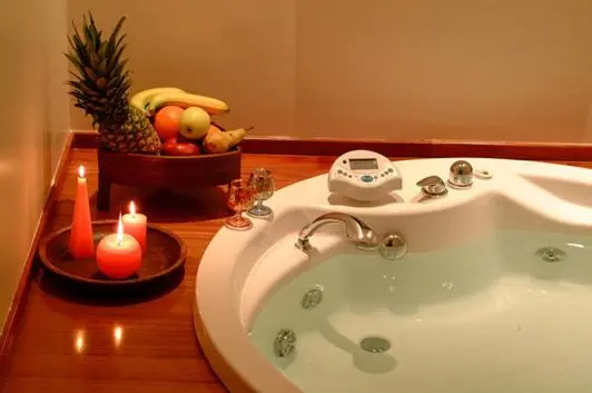 Baignoire hydromassante avec fruits frais et bougies.