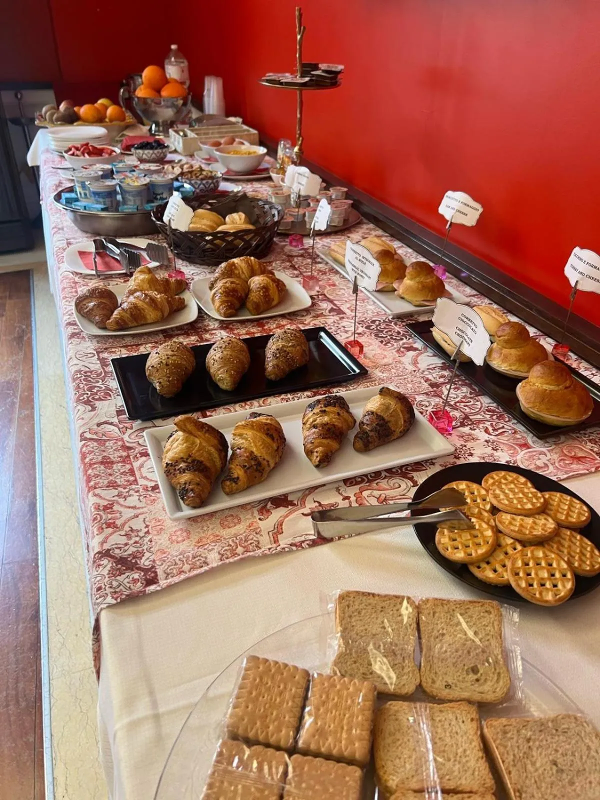 Une table garnie de viennoiseries, de fruits et de boissons.