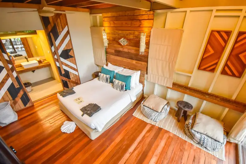 Une chambre lumineuse avec un grand lit et une décoration en bois.