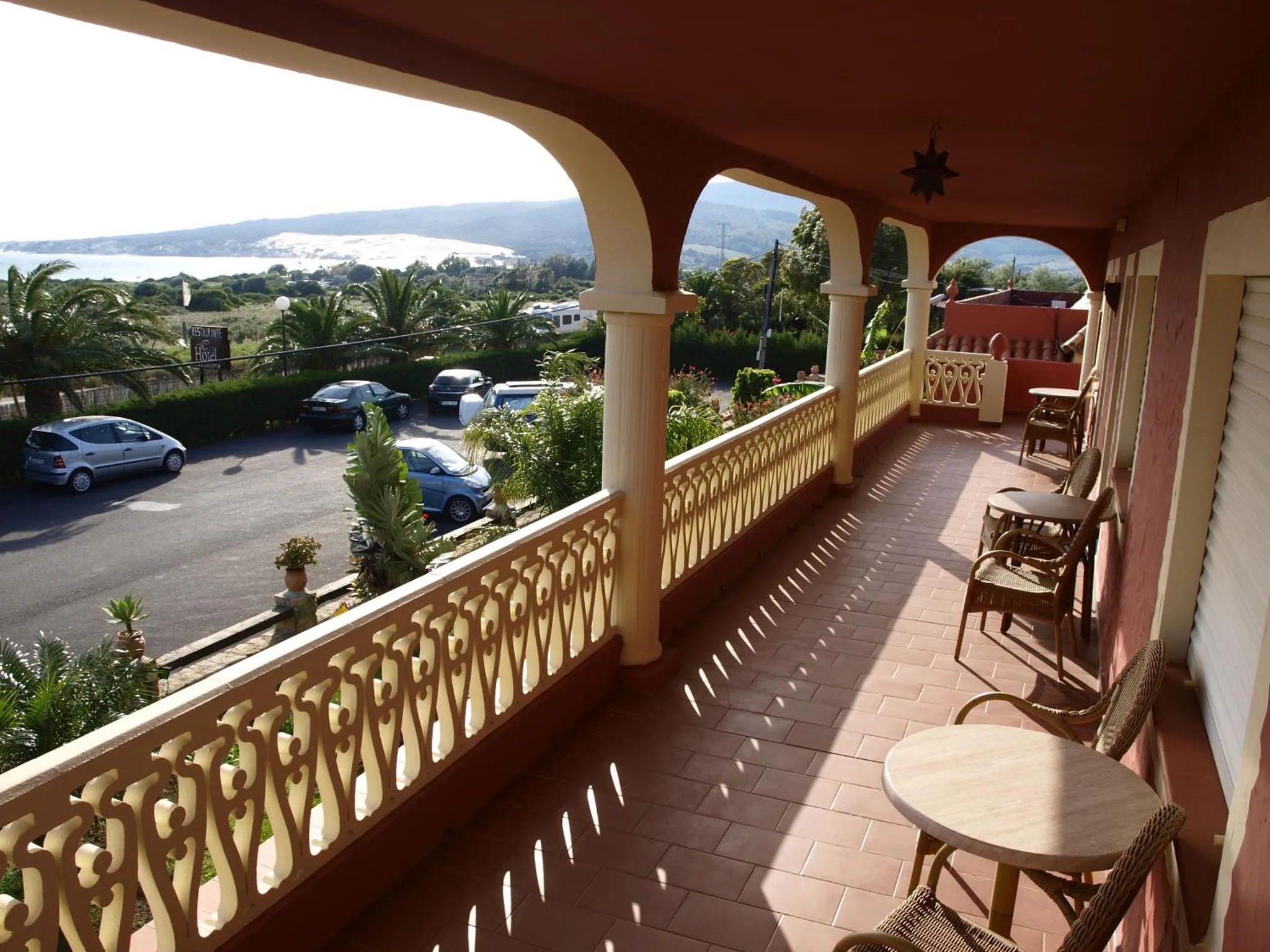 Terrasse carrelée avec vue sur la mer et les collines environnantes.