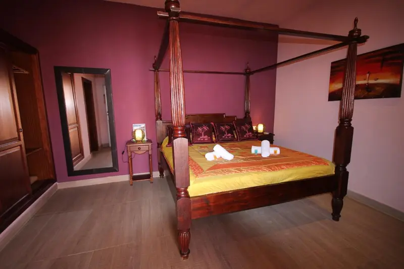 Une chambre avec un grand lit à baldaquin et une décoration soignée.