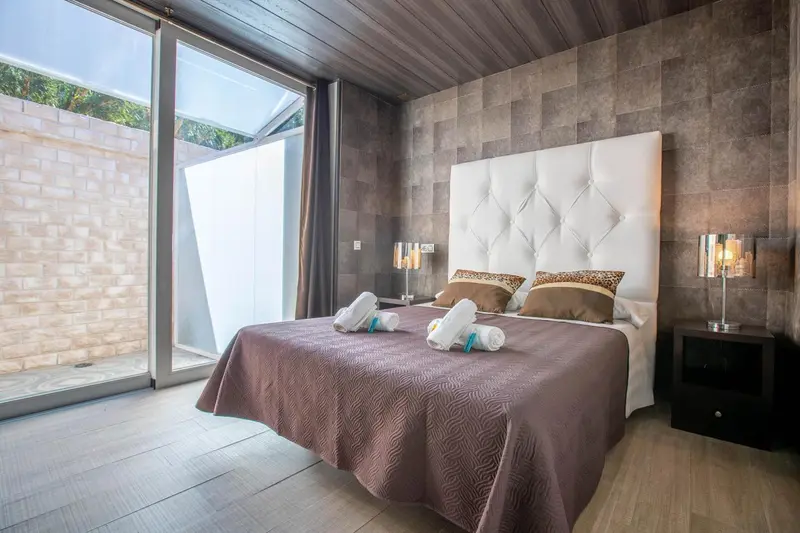 Une chambre moderne avec un grand lit et des fenêtres coulissantes.