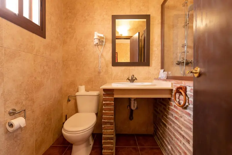 Petite salle de bain carrelée avec douche et lavabo.