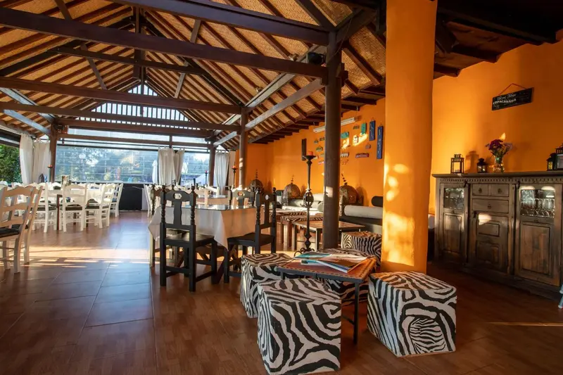 Une salle à manger lumineuse avec des tables nappées et un décor coloré.
