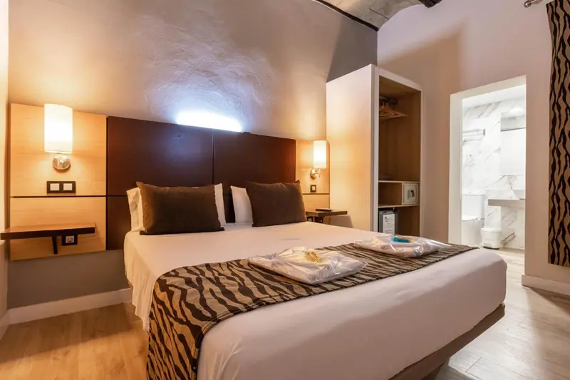 Une chambre avec un grand lit et une salle de bain attenante.