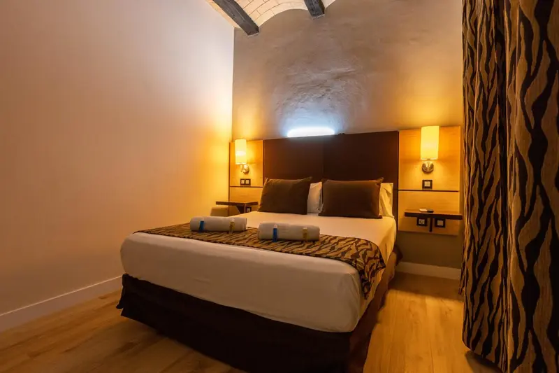 Une chambre avec un grand lit et des lampes de chevet.