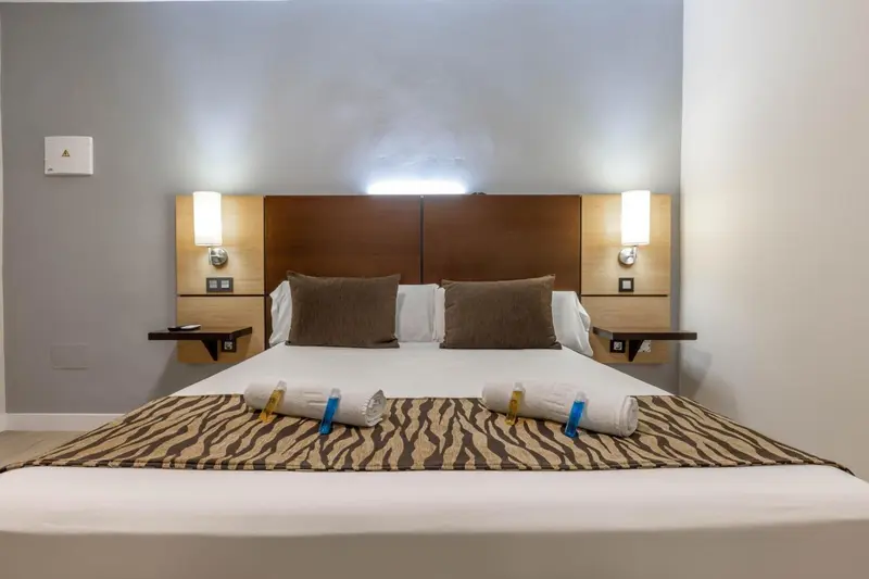 Une chambre avec un grand lit recouvert d'une courtepointe et de coussins.