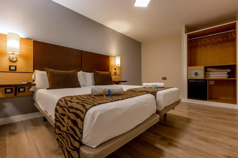 Une chambre avec un grand lit recouvert d'une courtepointe décorative et de coussins.