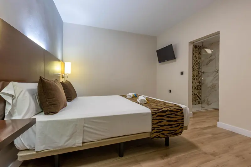 Une chambre lumineuse avec un grand lit et un accès à une salle de bain.