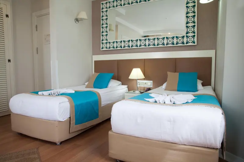 Une chambre lumineuse avec deux lits simples et une décoration soignée.
