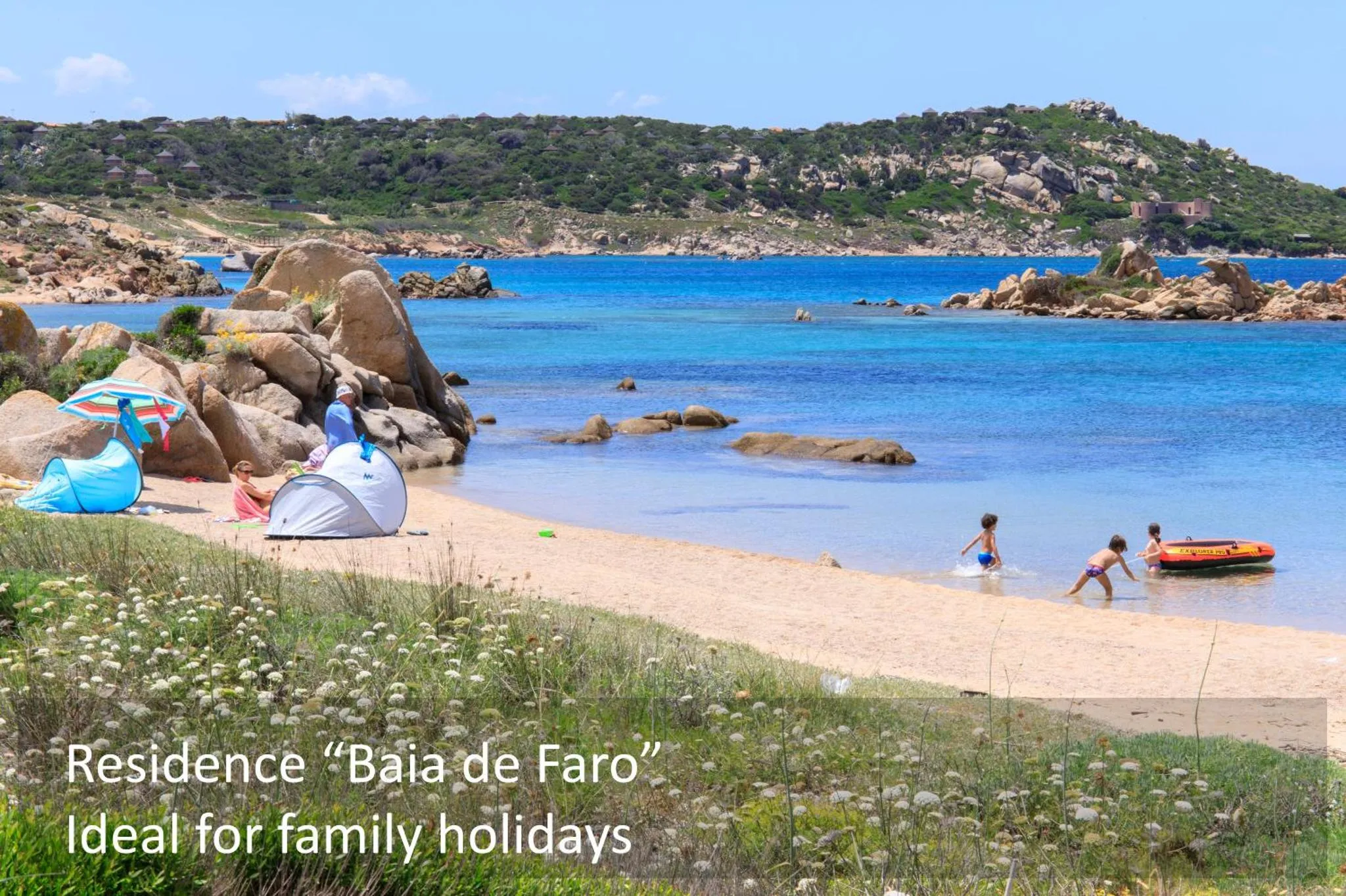 Une plage de sable avec des parasols et des personnes se baignant dans une mer turquoise.