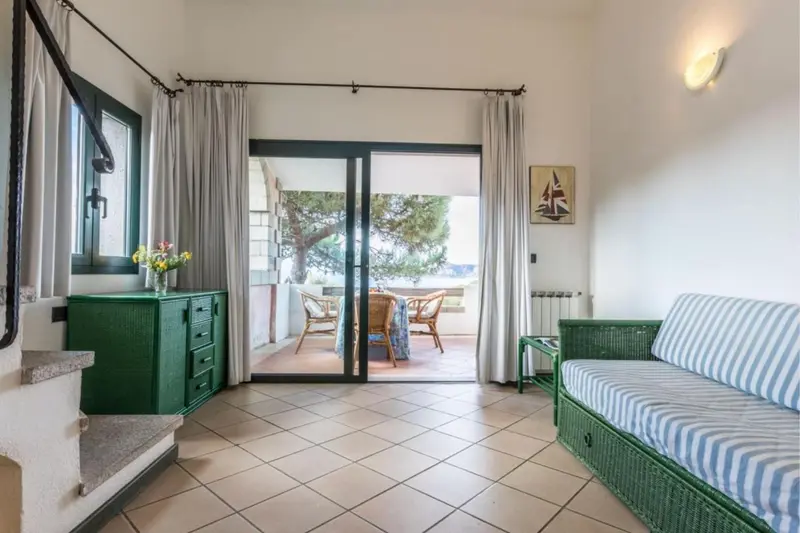 Espace de vie lumineux avec canapé et accès à une terrasse.