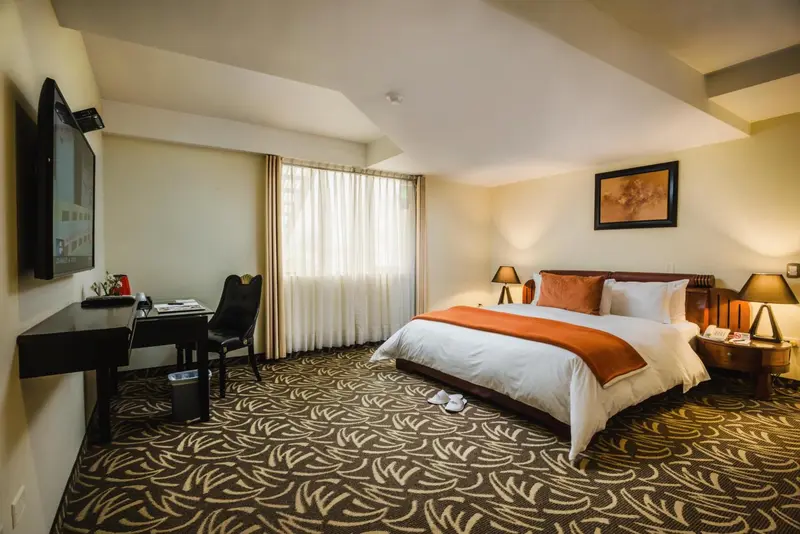 Une chambre d'hôtel lumineuse avec un grand lit et un bureau.