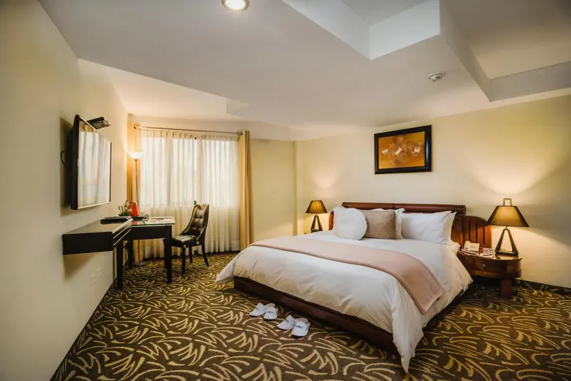 Une chambre d'hôtel lumineuse avec un grand lit et un bureau.