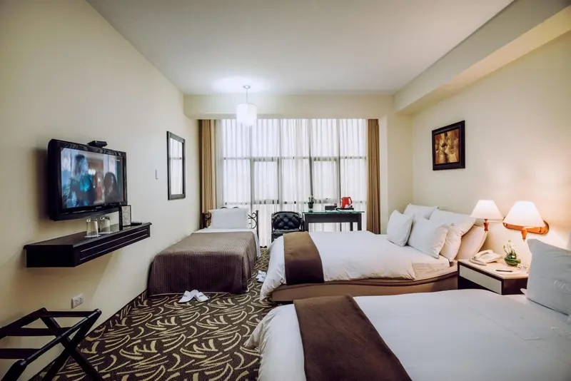 Une chambre d'hôtel avec deux lits et un bureau.