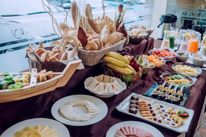 Une table garnie de viennoiseries, de fruits et de préparations salées.