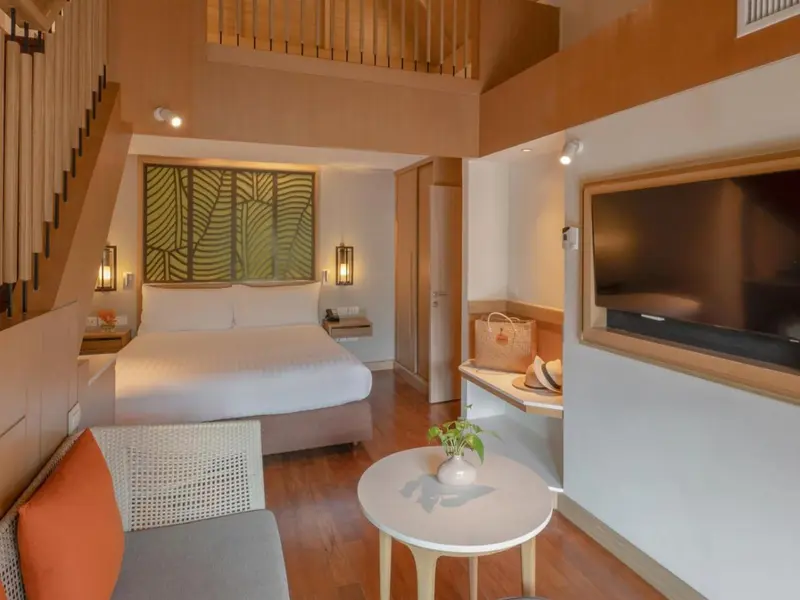 Une chambre lumineuse avec un lit double et un espace salon.