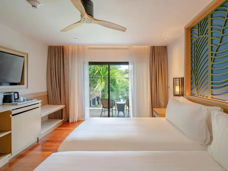 Chambre lumineuse avec un grand lit et une vue sur une terrasse.