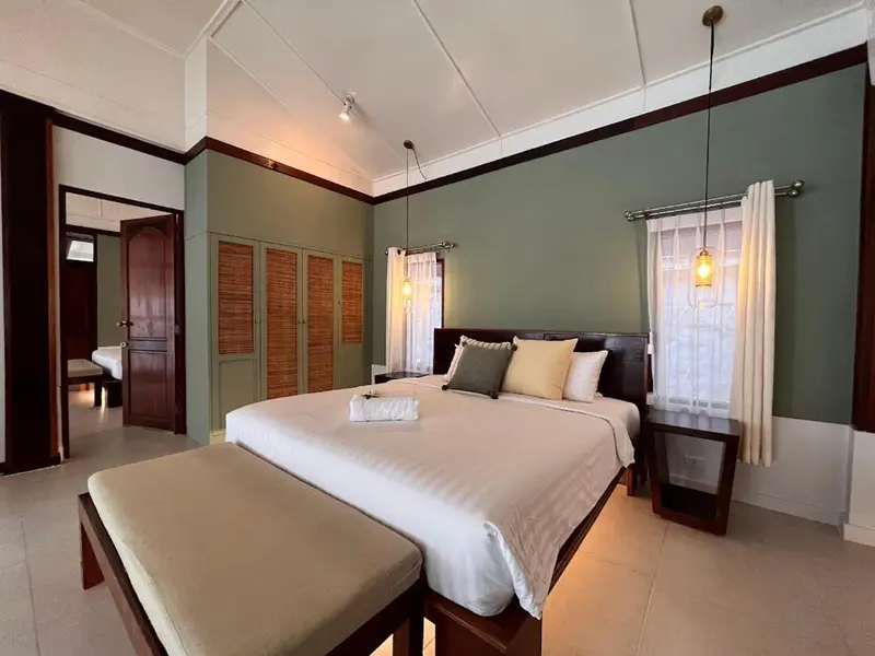 Une chambre lumineuse avec un grand lit et un coin salon.