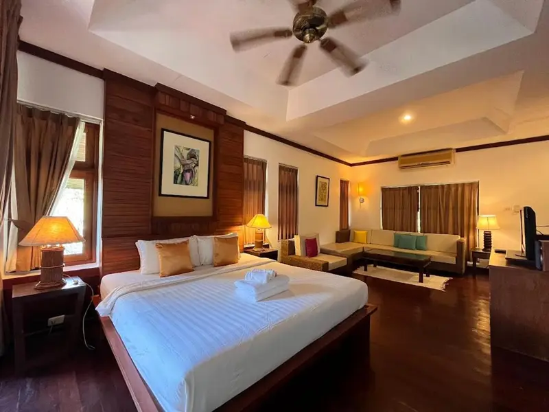Une chambre spacieuse avec un grand lit et un coin salon.