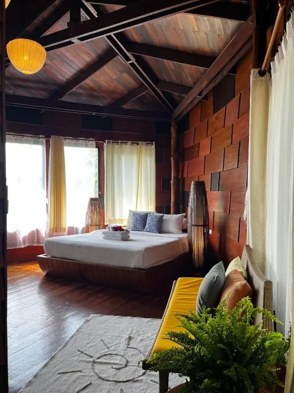 Une chambre lumineuse avec un grand lit et un coin salon.