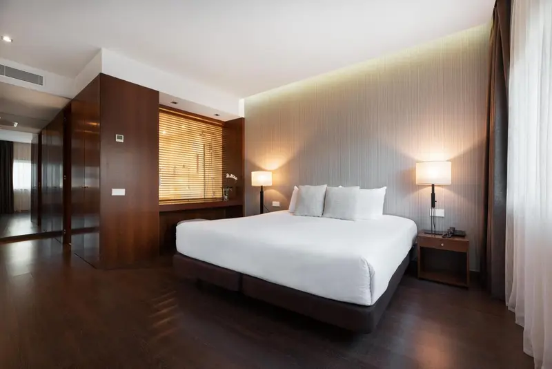 Une chambre lumineuse avec un grand lit et un bureau.