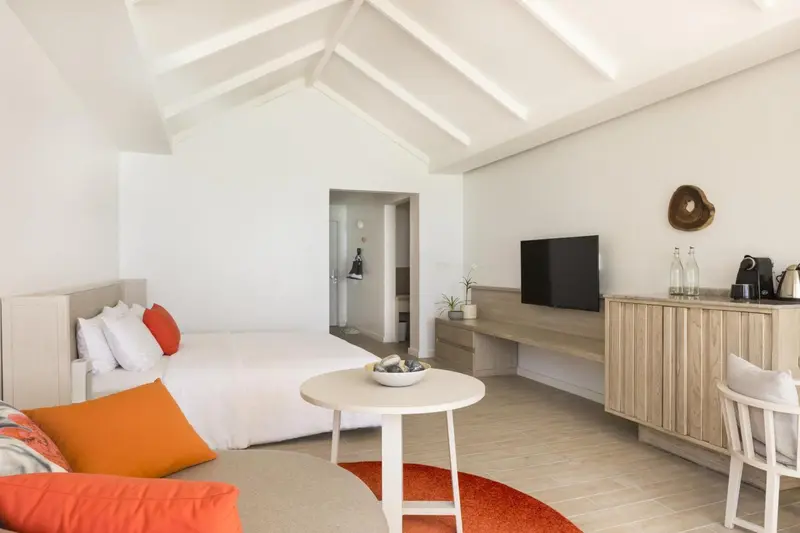 Une chambre lumineuse avec un lit et un espace détente.