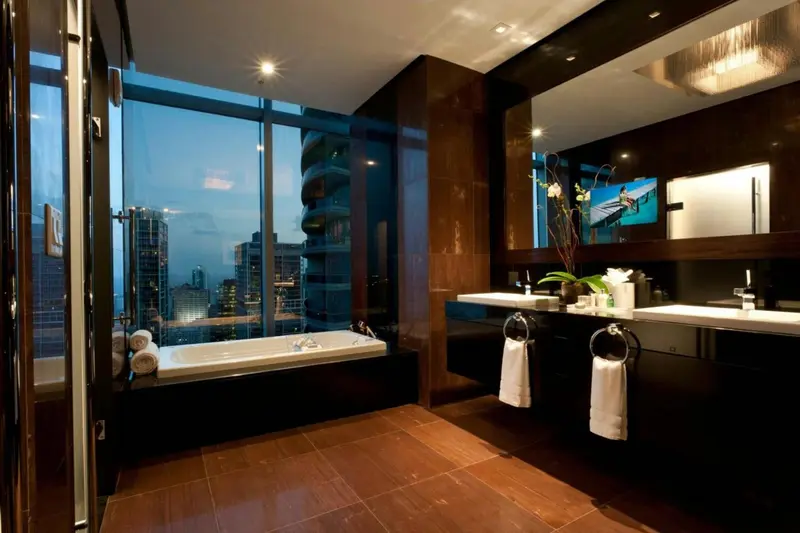 Une salle de bain moderne avec baignoire et vue sur la ville.